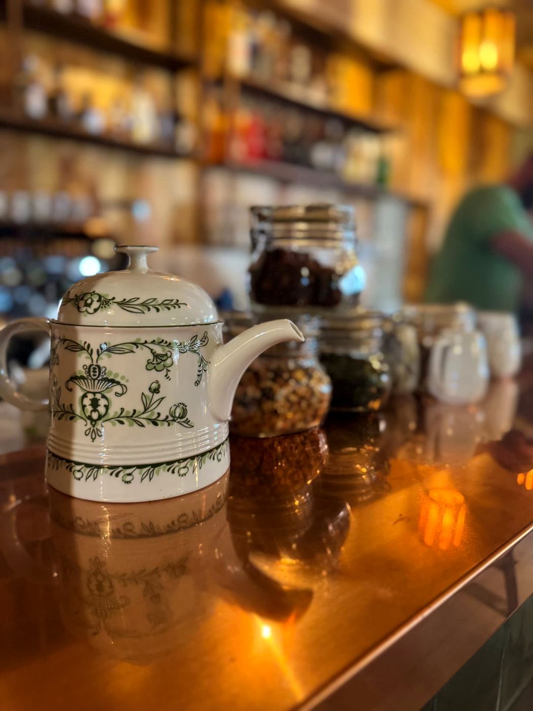 Teiera in porcellana decorata e barattoli di tè sul bancone