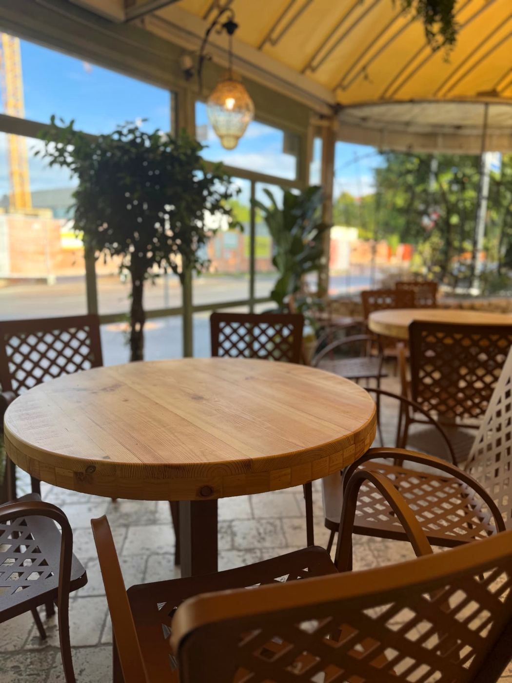 Tavolini in legno nella veranda luminosa del bar
